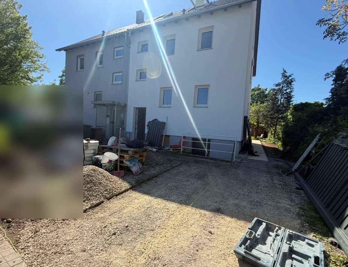 Wohngebäude mit vorbereiteter Außenanlage während laufender Sanierungsarbeiten