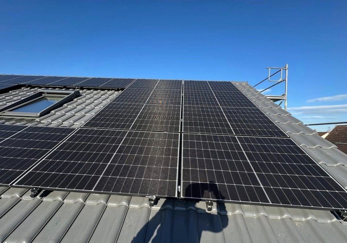 Photovoltaikanlage auf einem Ziegeldach unter blauem Himmel